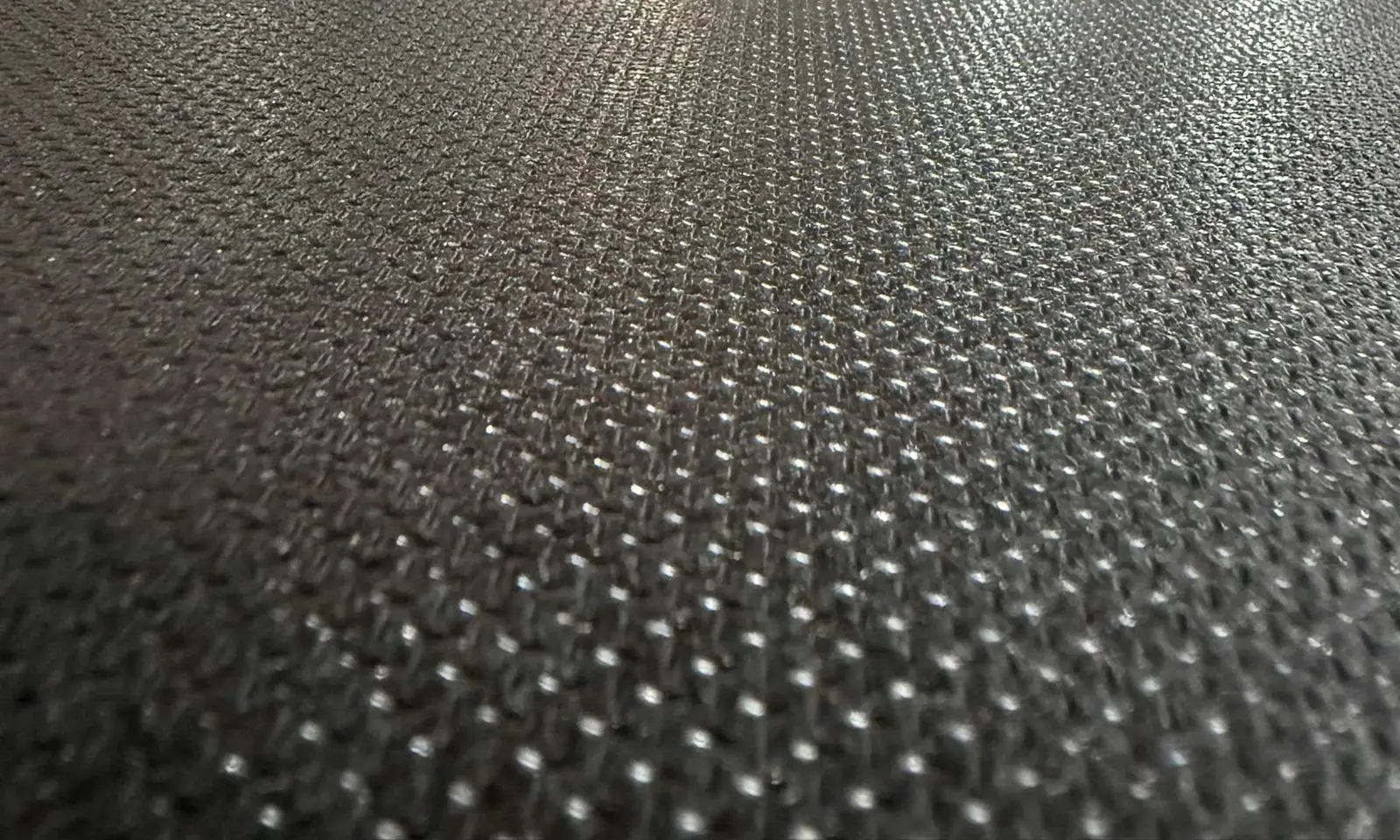 Dark brown anti-slip plywood face covered in small raised rice-grain embossing
